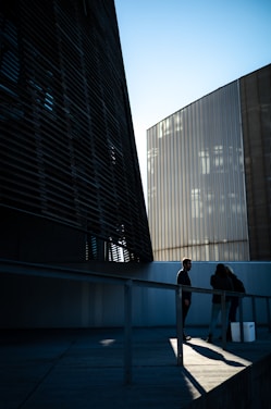 a couple of people standing next to a tall building