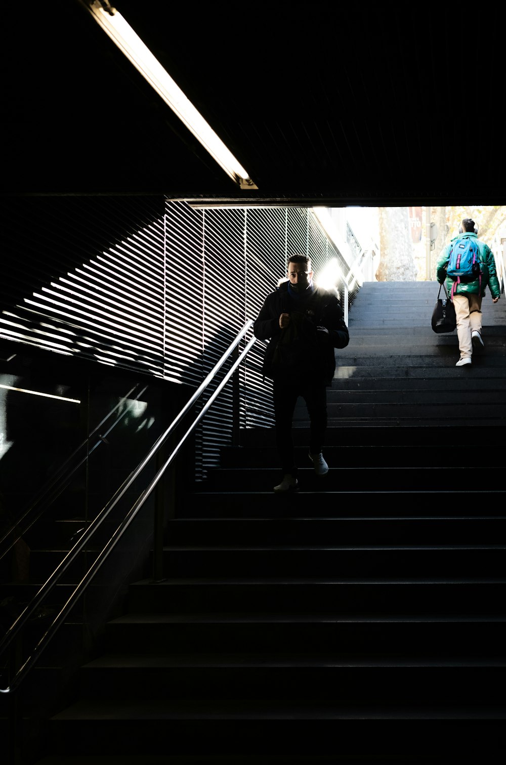 a couple of people walking down a set of stairs