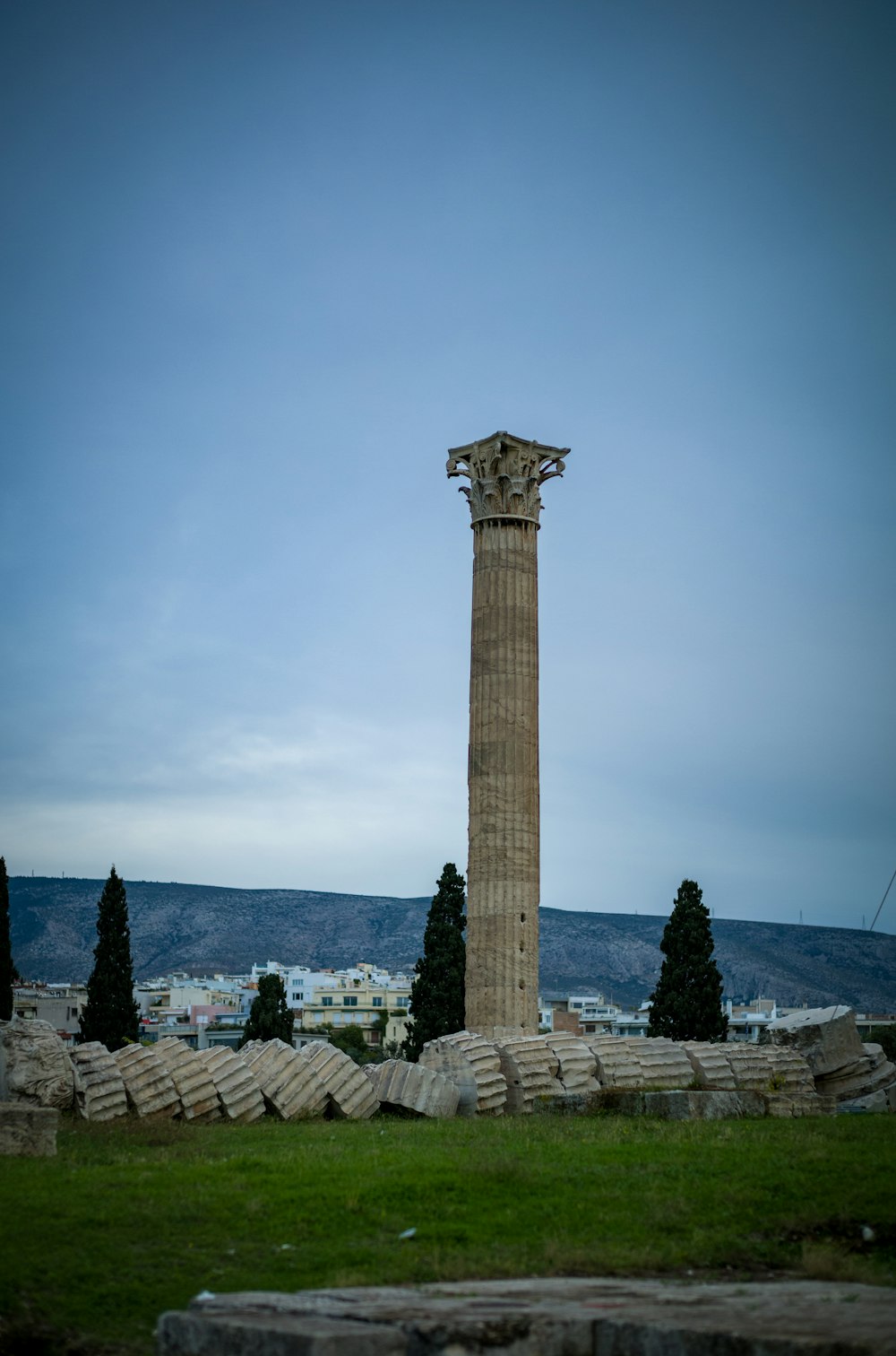 a tall stone pillar sitting on top of a lush green field