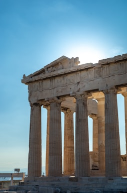 Ancient Greek temple facade bathed in golden light at sunset, evoking timeless wisdom.
