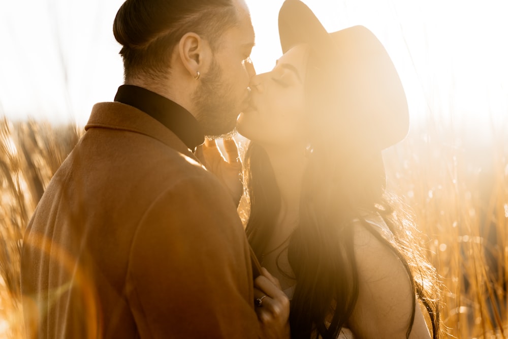 a man and a woman kissing in a field