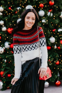 a woman standing in front of a christmas tree