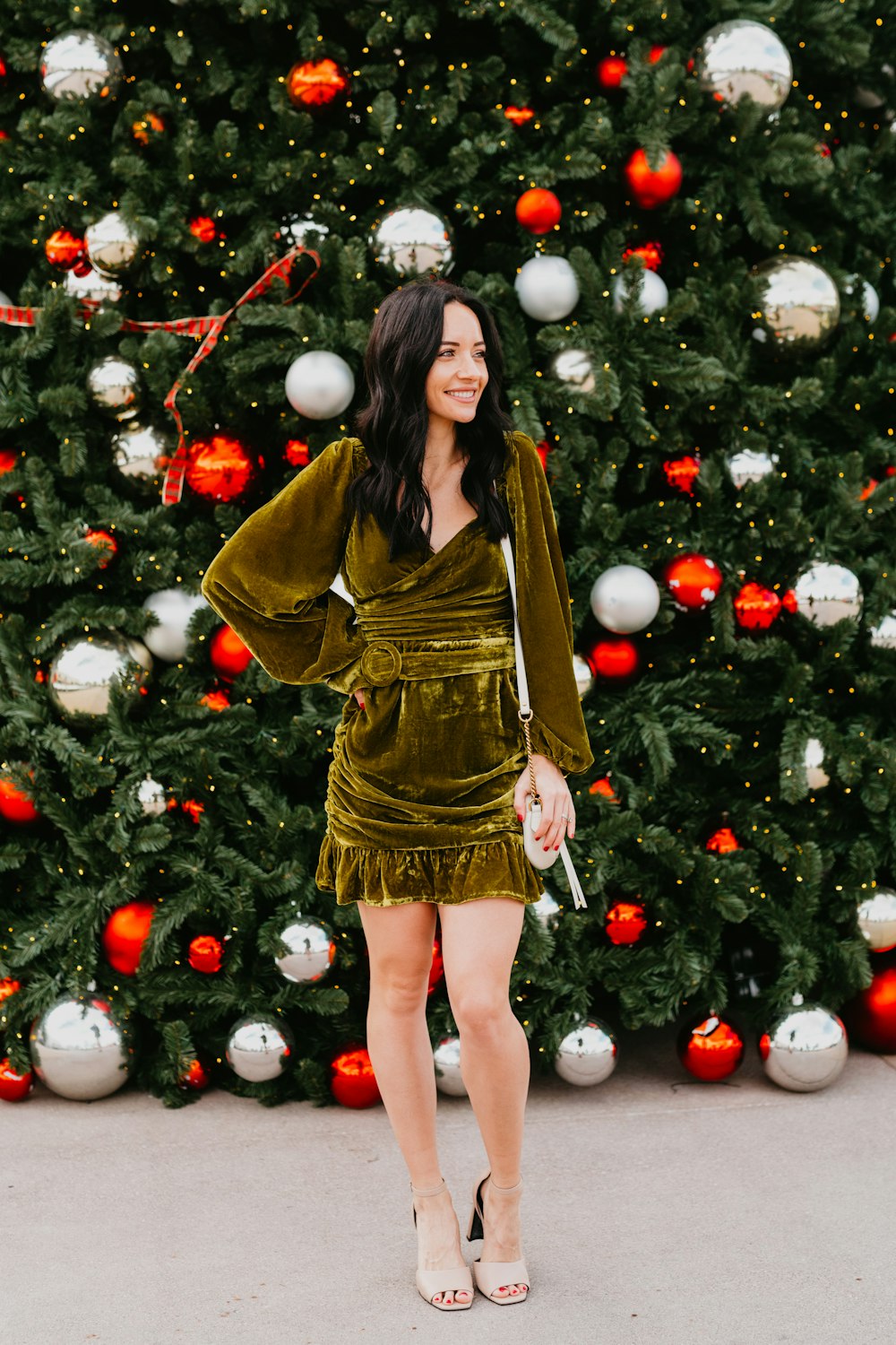 a woman standing in front of a christmas tree