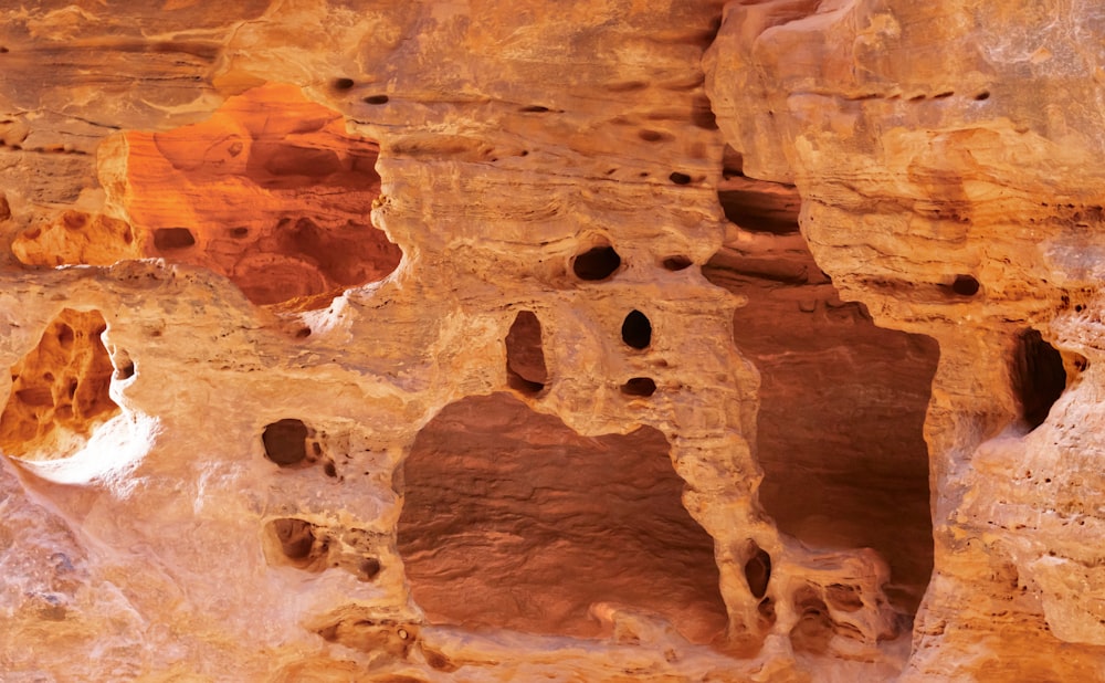 a group of holes in the side of a cliff