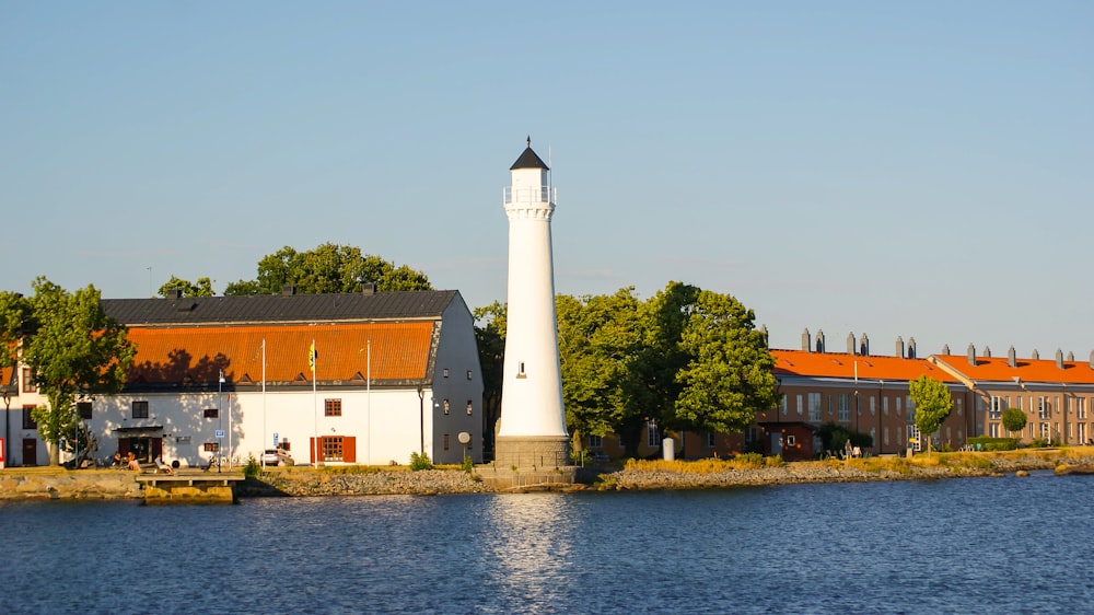a light house sitting on the side of a body of water