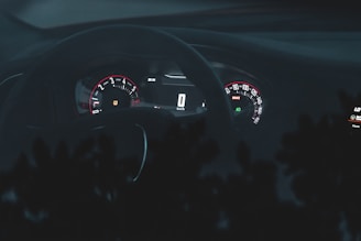 A sleek car dashboard with glowing gauges at dusk.