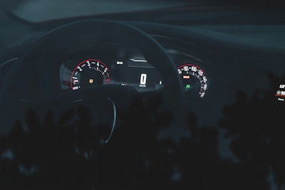 A sleek car dashboard with glowing gauges at dusk.