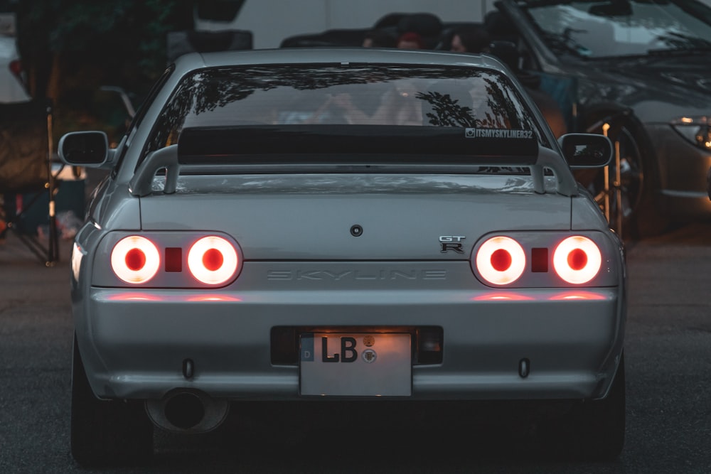 a car with its lights on in a parking lot