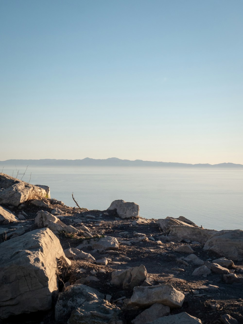 a large body of water sitting next to a rocky shore