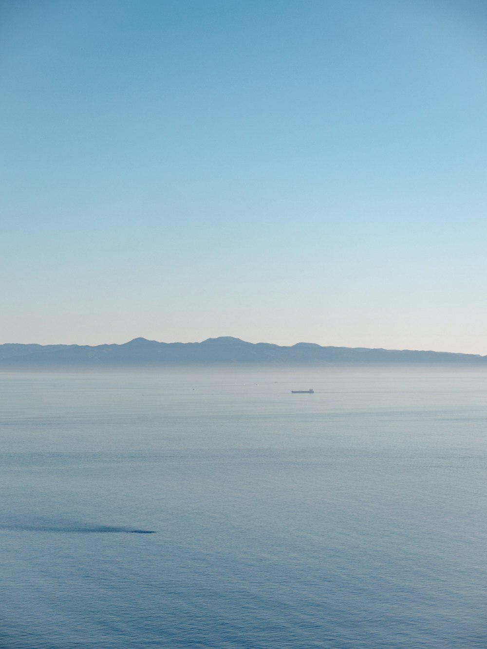 a large body of water with mountains in the background