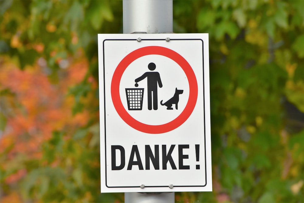a street sign with a dog and a man in a basket