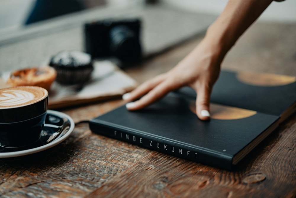 a cup of coffee and a book on a table