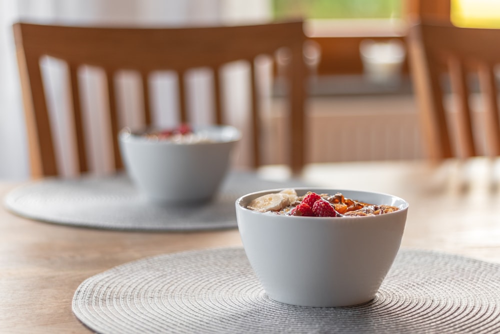 a bowl of cereal sits on a placemat on a table