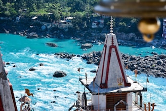 A tranquil scene of a temple beside a flowing river, representing spiritual devotion.