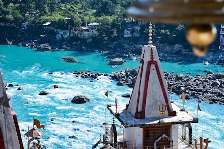 A tranquil scene of a temple beside a flowing river, representing spiritual devotion.