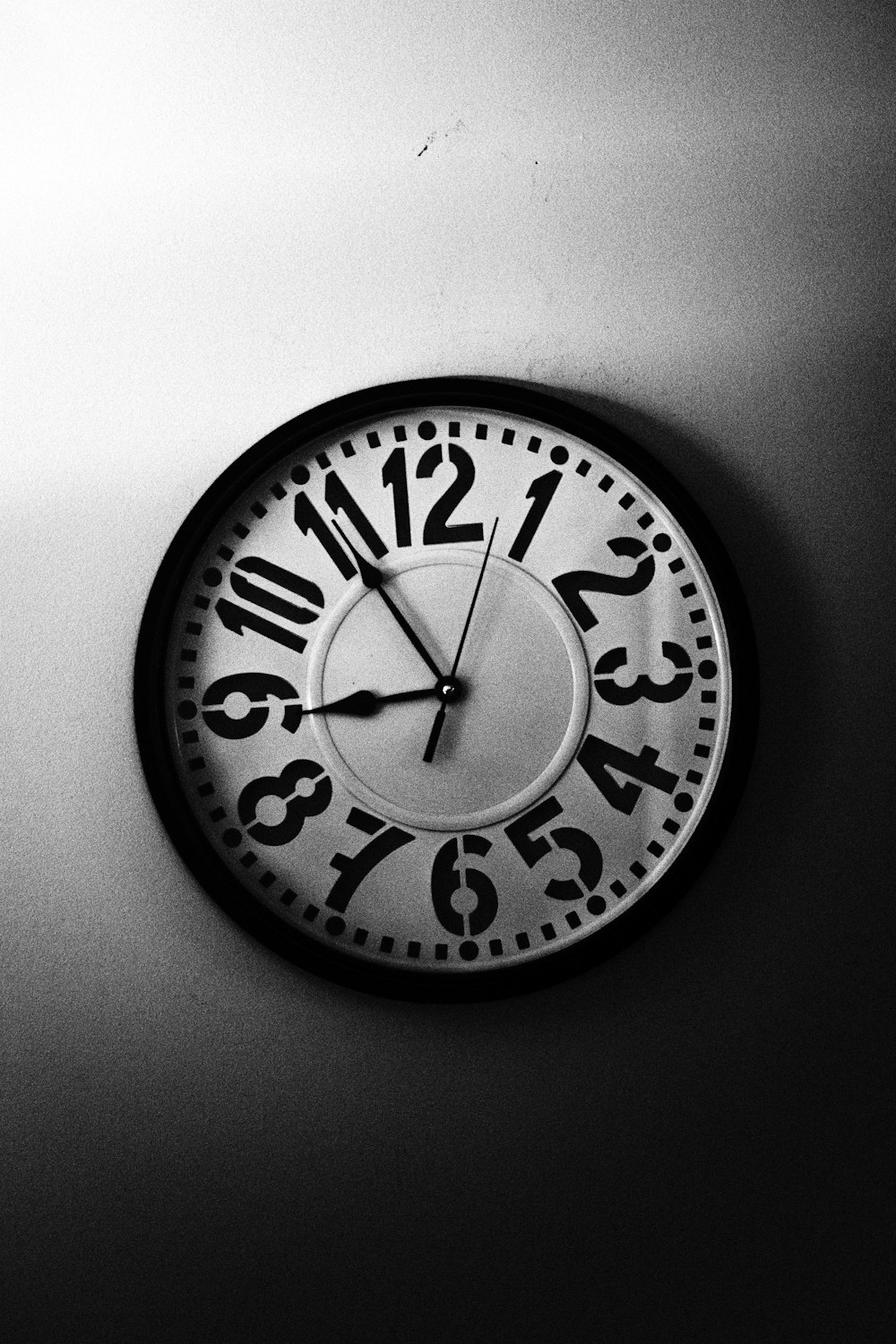 a black and white photo of a clock on a wall