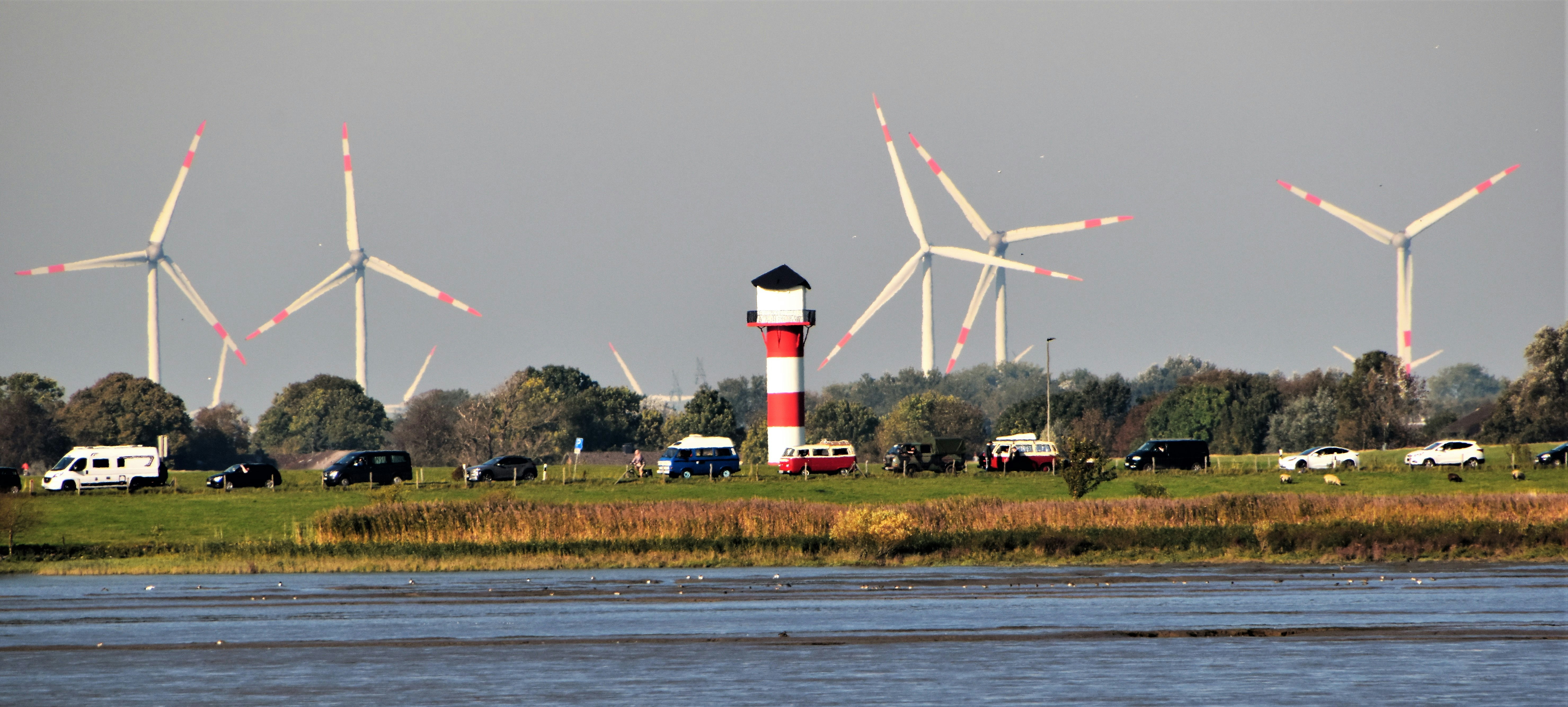 Wind Turbine and a lighthouse with waiting cars for a ferry