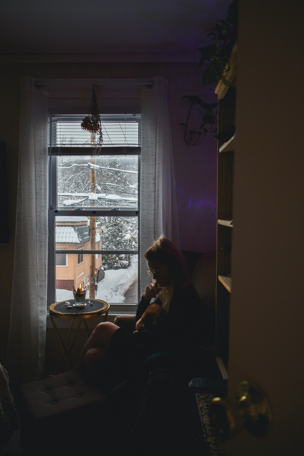 a woman sitting in a chair in front of a window