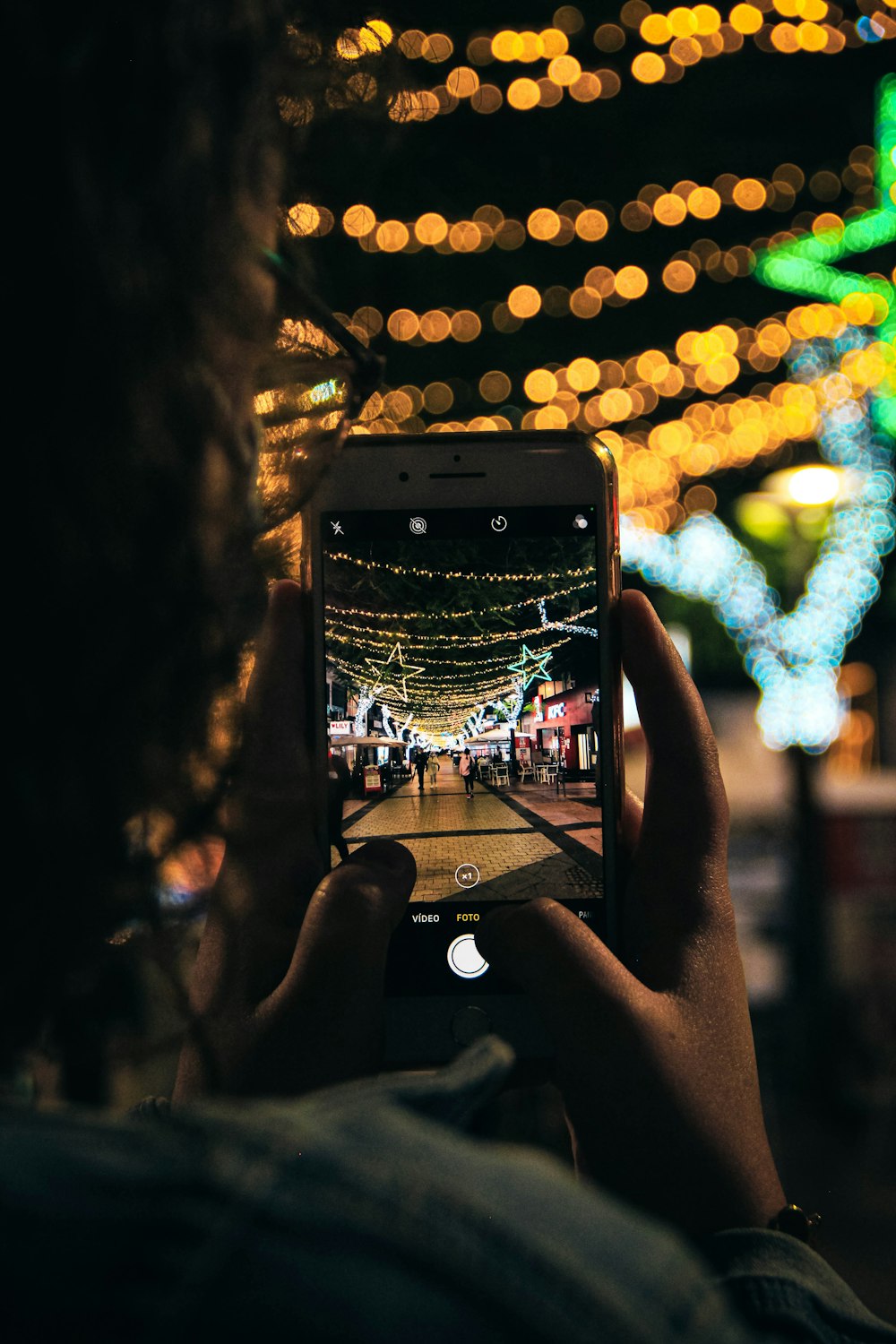 a person taking a picture of a street at night