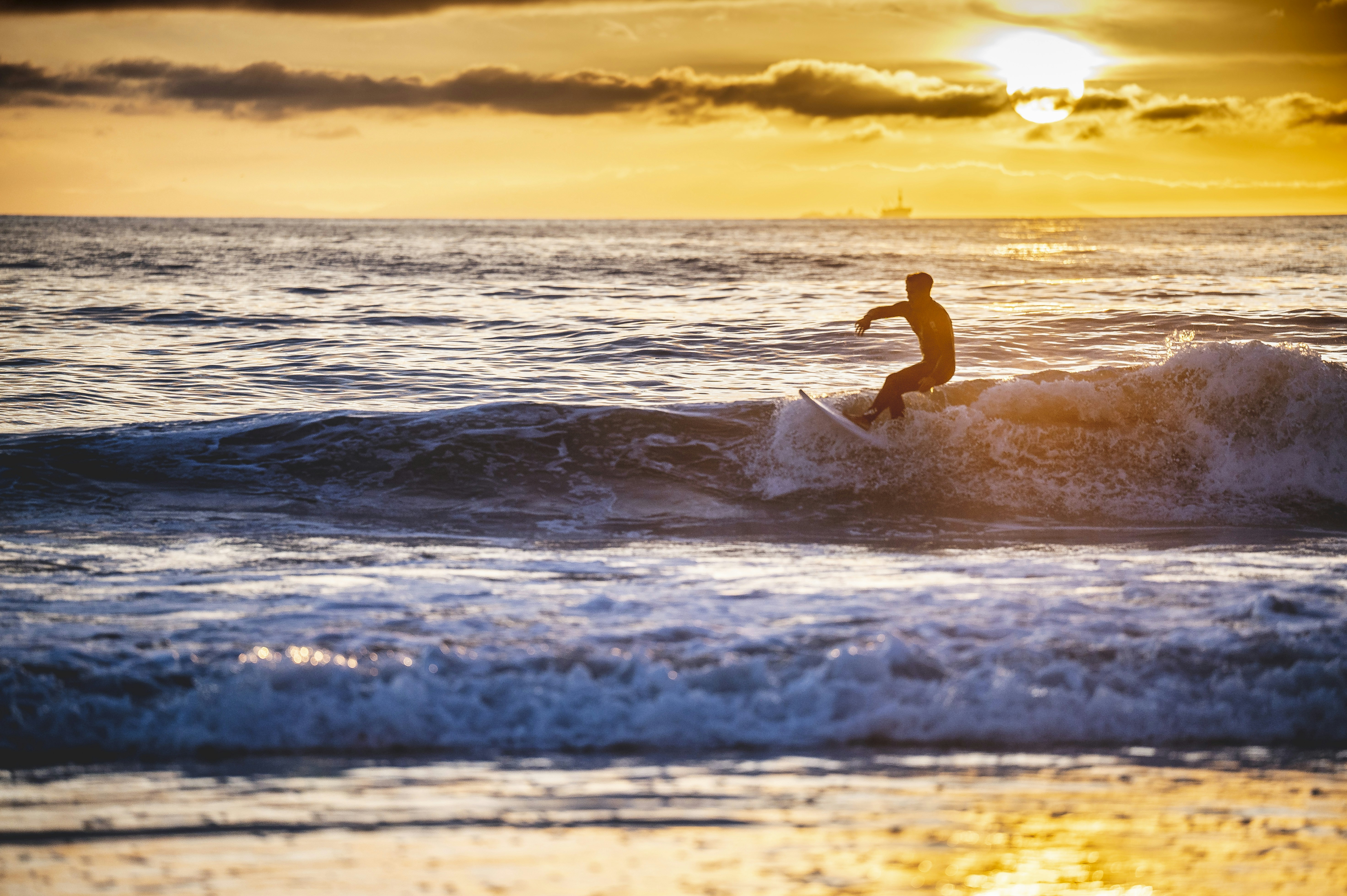 a man riding a wave on top of a surfboard