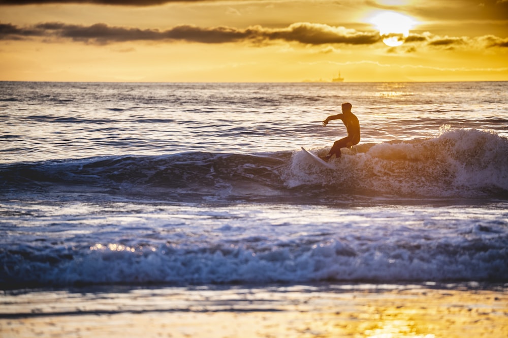 a man riding a wave on top of a surfboard