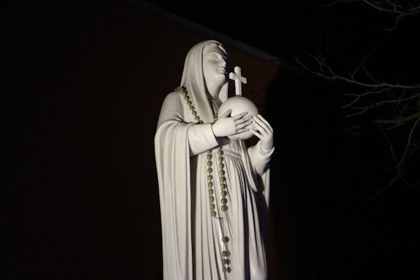 A serene statue of Saint Jude holding a flame, symbolizing hope in darkness.