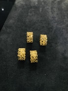 Stacked gold rings with subtle designs on a wooden surface