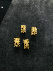 Stacked rings with intricate designs displayed on a rustic wooden surface.