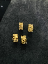 Beautiful gold rings with intricate designs displayed on a wooden tray