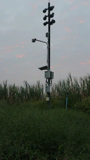 Mobile surveillance trailer stationed at a busy construction site during sunset, cameras actively monitoring the area
