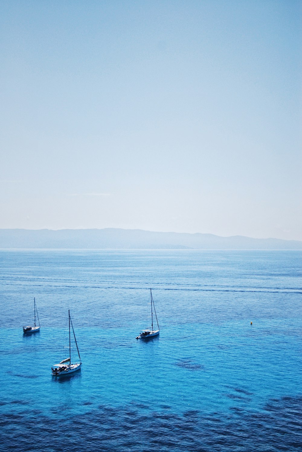 a group of boats floating on top of a large body of water