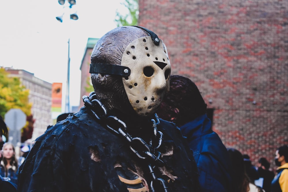 a person wearing a mask and chain around their neck