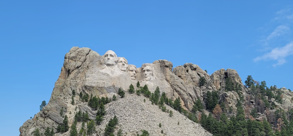 Una gran montaña con un grupo de estatuas en la cima