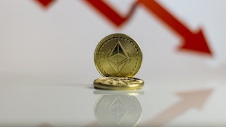 A gold-colored coin with Ethereum's symbol is prominently displayed against a backdrop of a red downward arrow, symbolizing a decrease or decline.