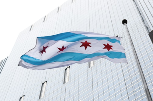 a flag flying in front of a tall building