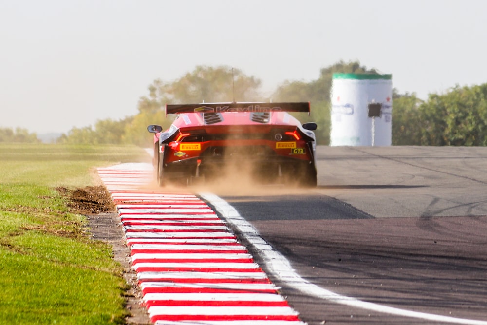 a red sports car driving down a race track