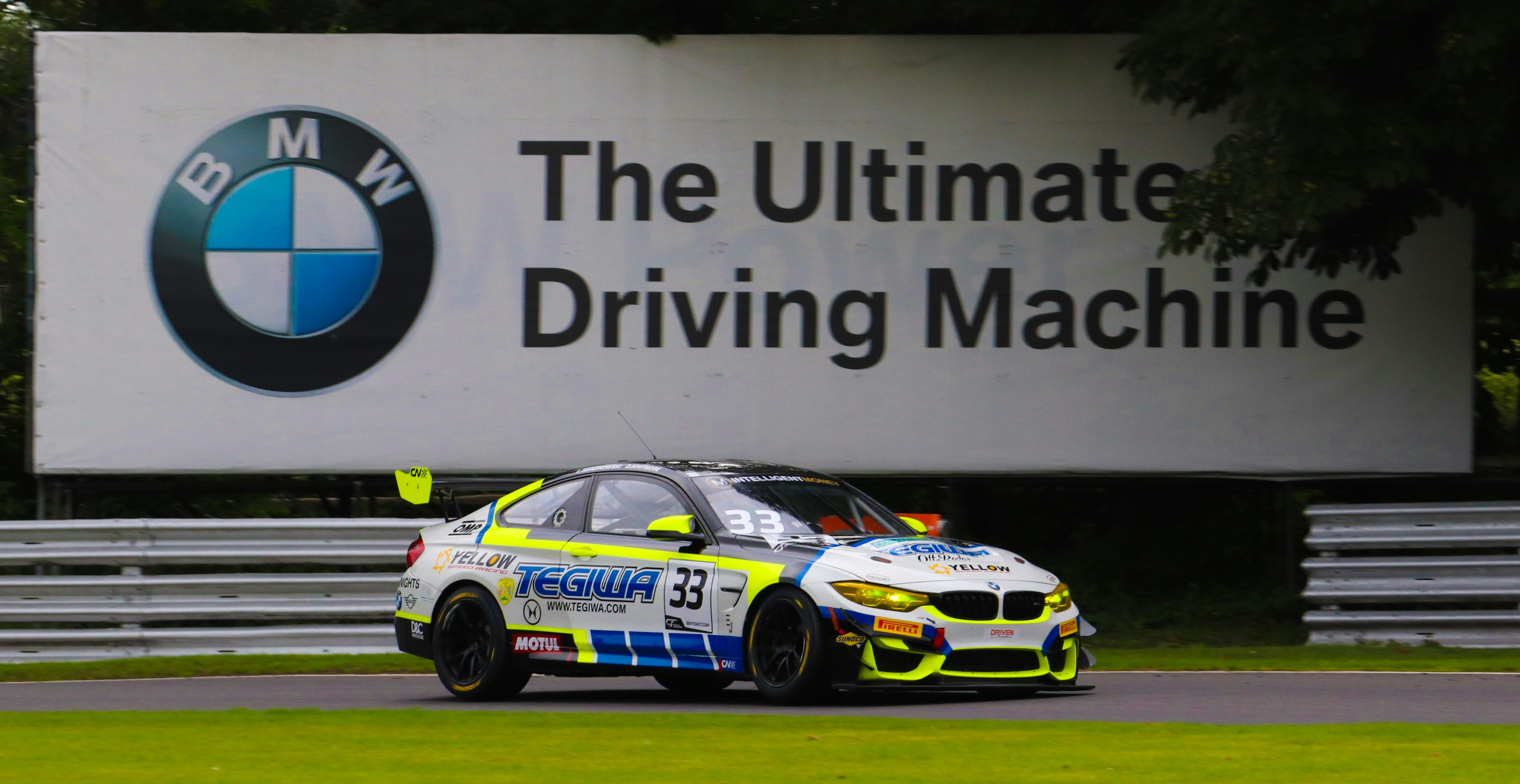 a car driving on a race track near a sign