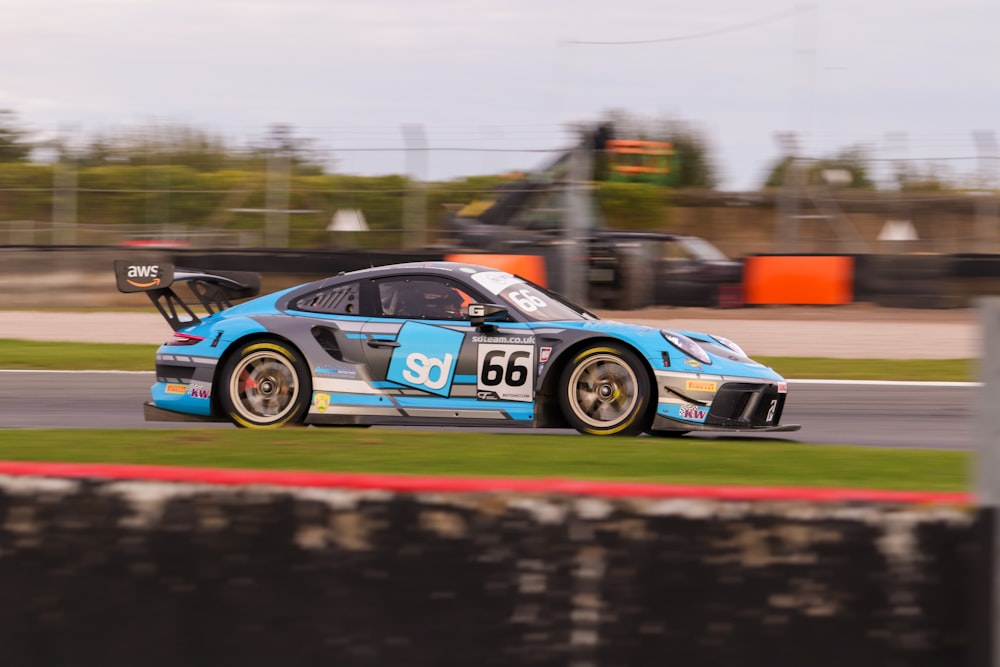 a blue race car driving down a race track