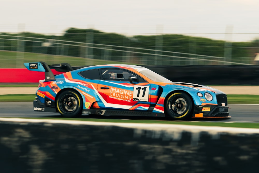 a blue and orange car driving down a race track