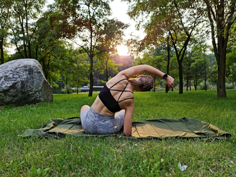 a woman is doing yoga in a park
