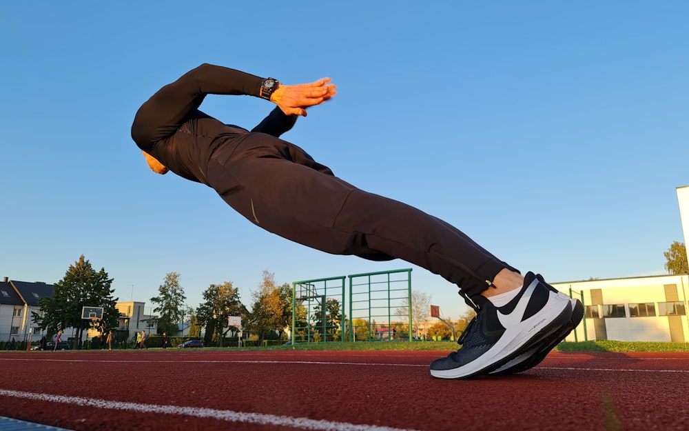 a man is doing a push up on a running track