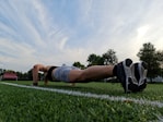 a woman is doing push ups on the grass