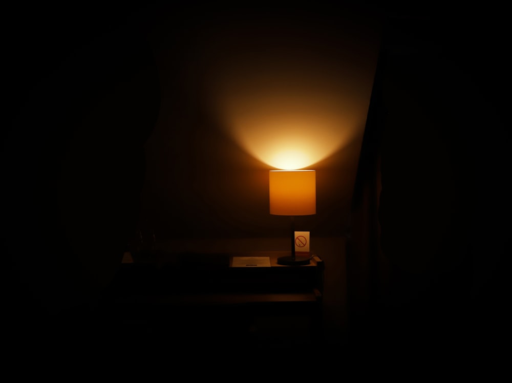 a dark room with a lamp on a table