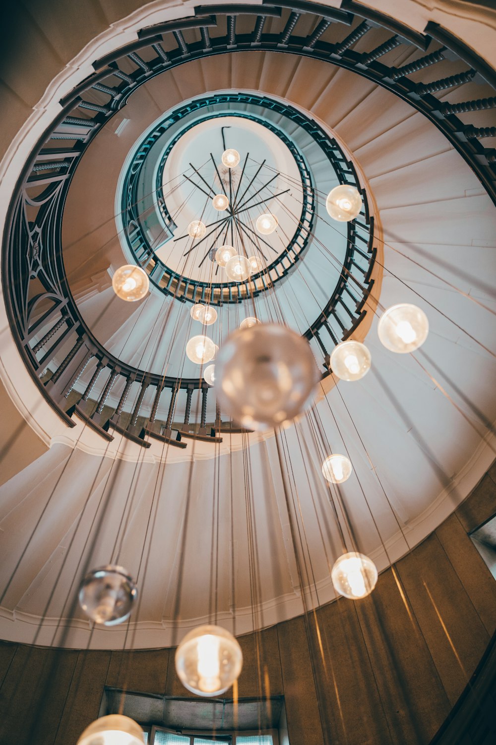 a spiral staircase with a chandelier hanging from the ceiling