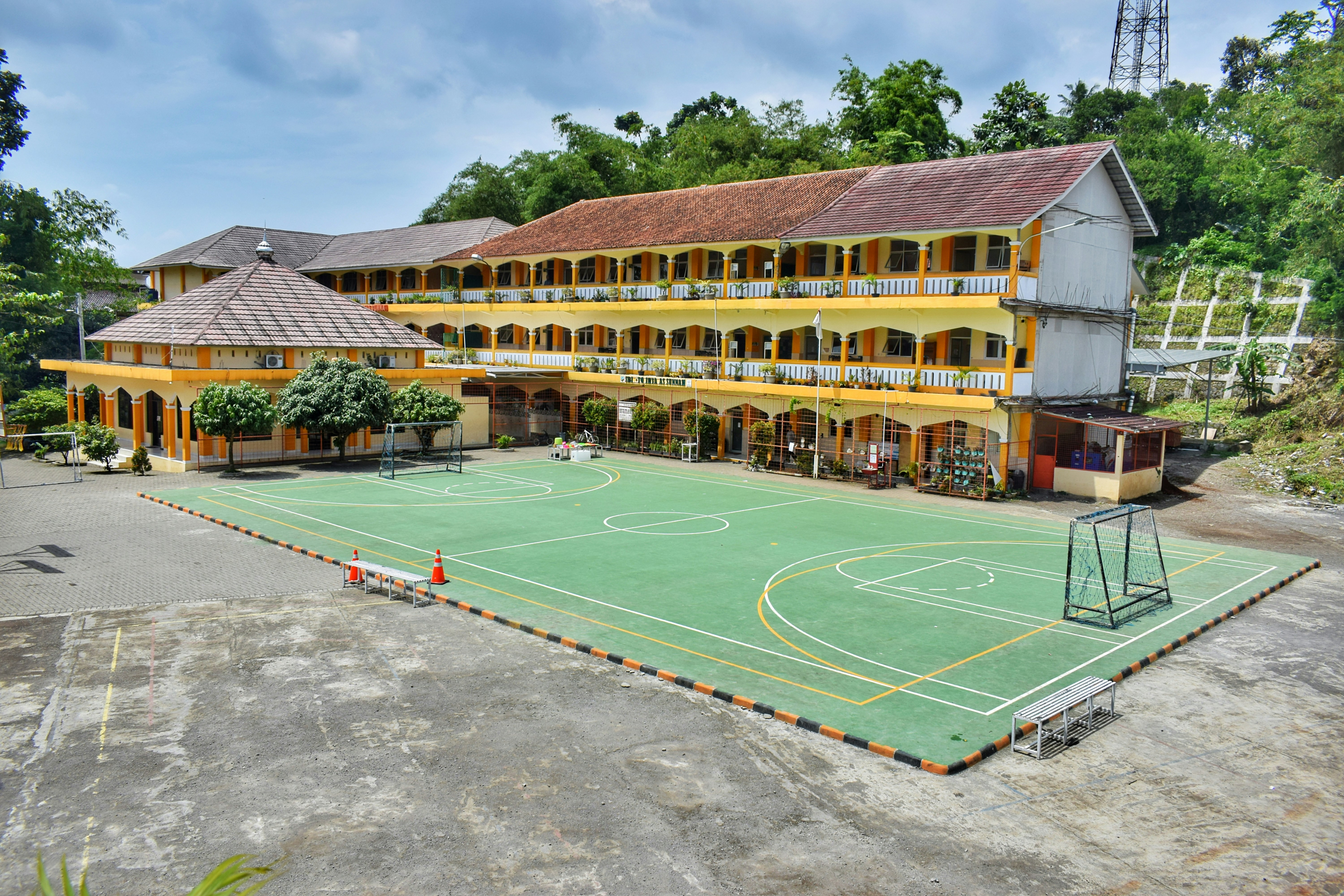 a large building with a basketball court in front of it