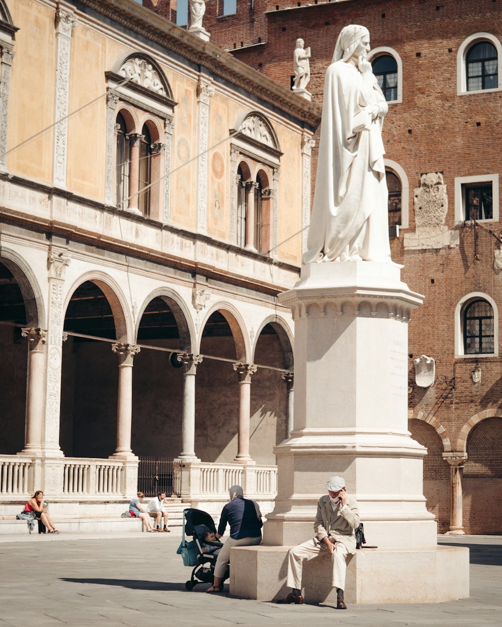 a man sitting on a bench next to a statue