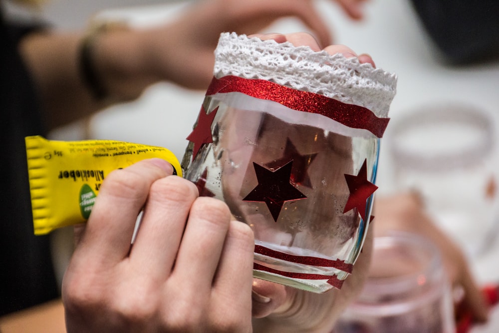 a person holding a wine glass with a red star on it