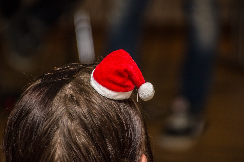 a young boy wearing a red and white santa hat