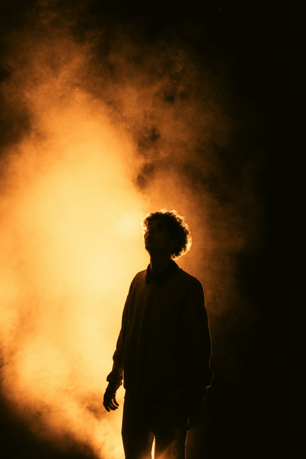 a man standing in front of a yellow light