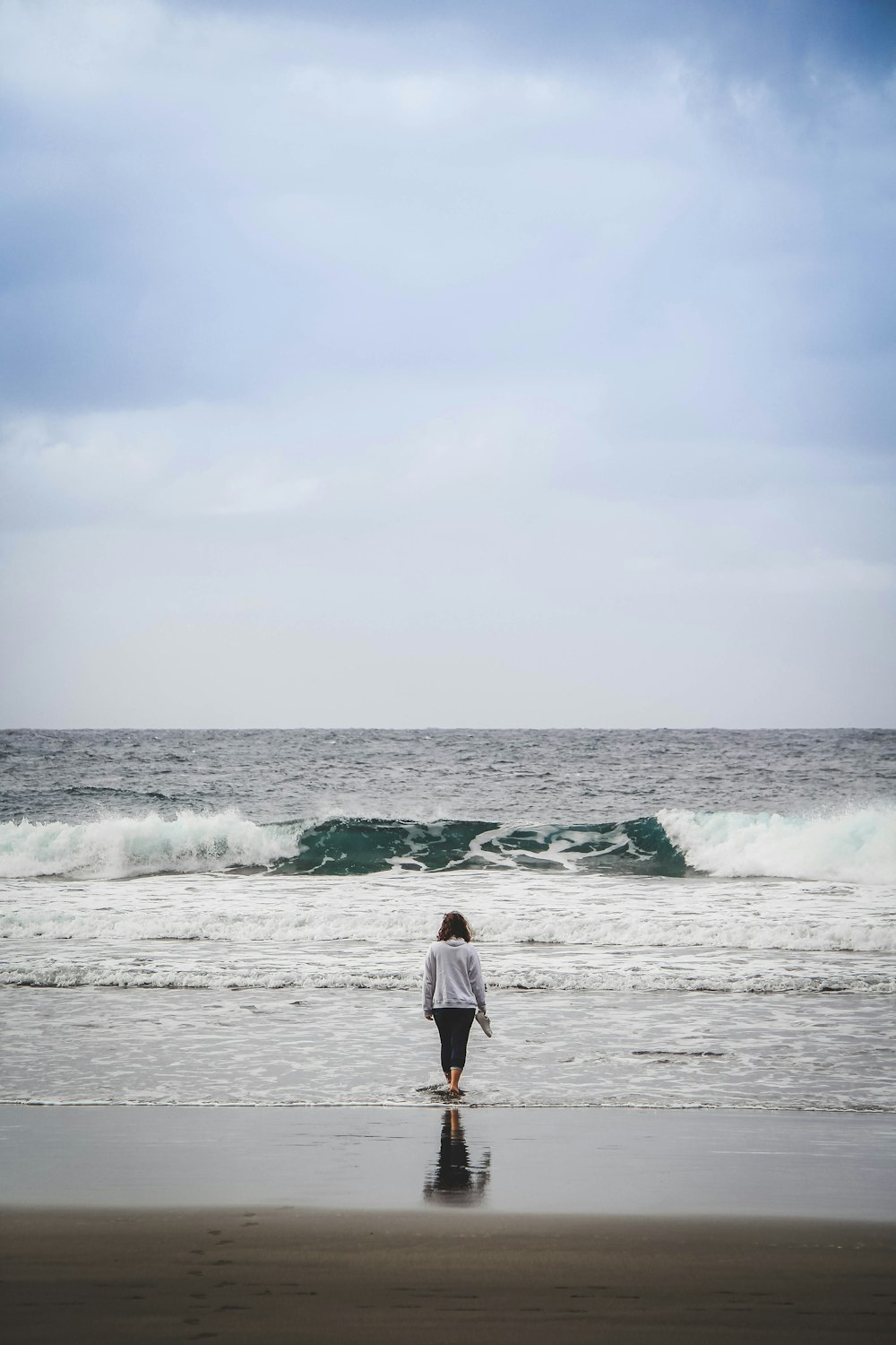 a person walking on the beach with a surfboard